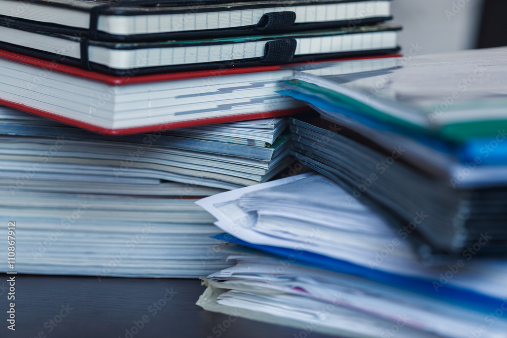 Accounting and taxes. Pile of magazine, notebook and books close Accounting and taxes. Pile of magazine, notebook and books close