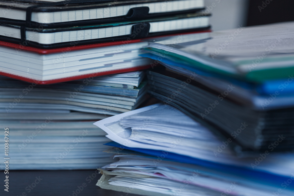 Accounting and taxes. Pile of magazine, notebook and books close Accounting and taxes. Pile of magazine, notebook and books close