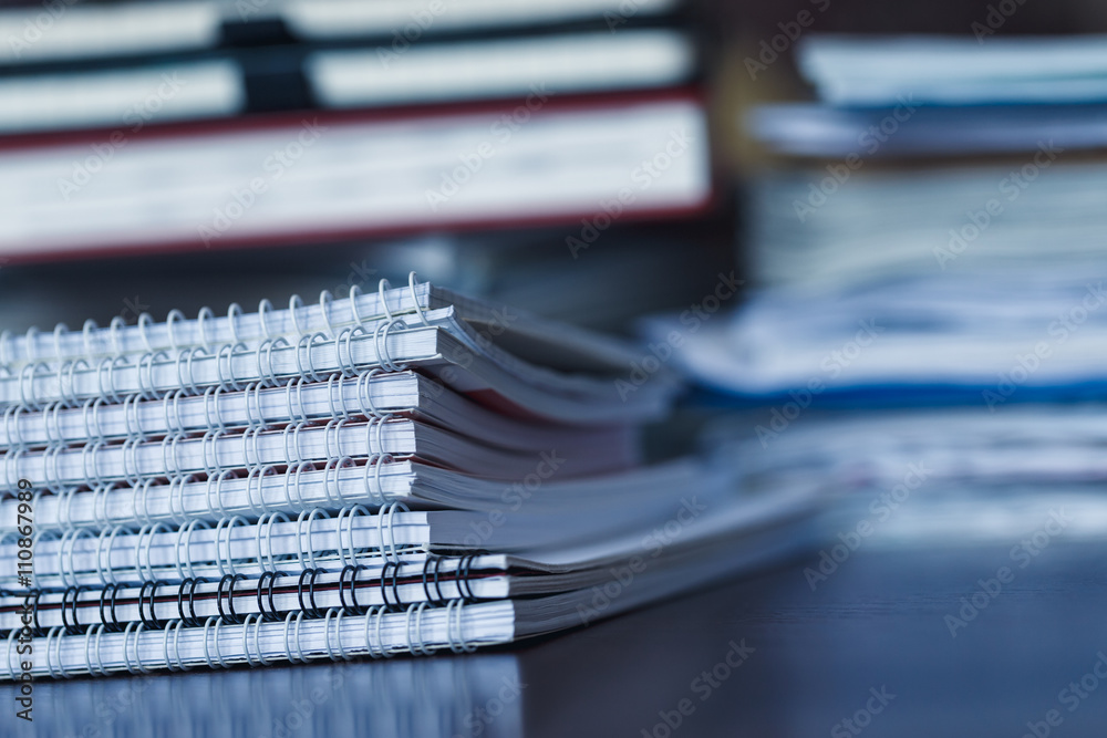Accounting and taxes. Pile of magazine, notebook and books close Accounting and taxes. Pile of magazine, notebook and books close