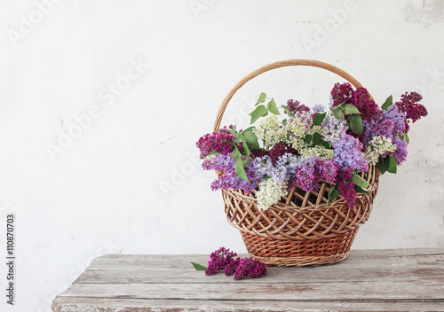 basket with a branch of lilac flower