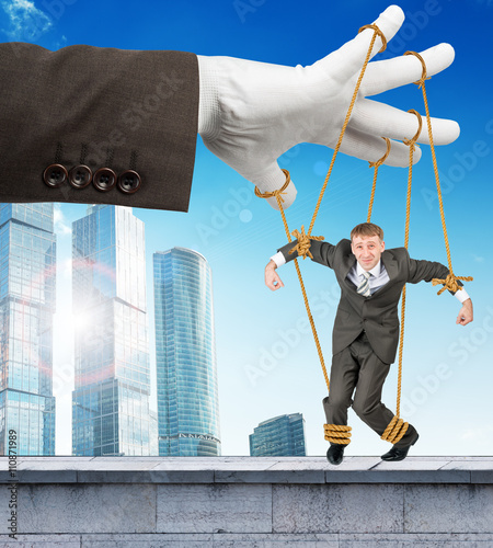 Fotografija Businessman hanging on strings like marionette