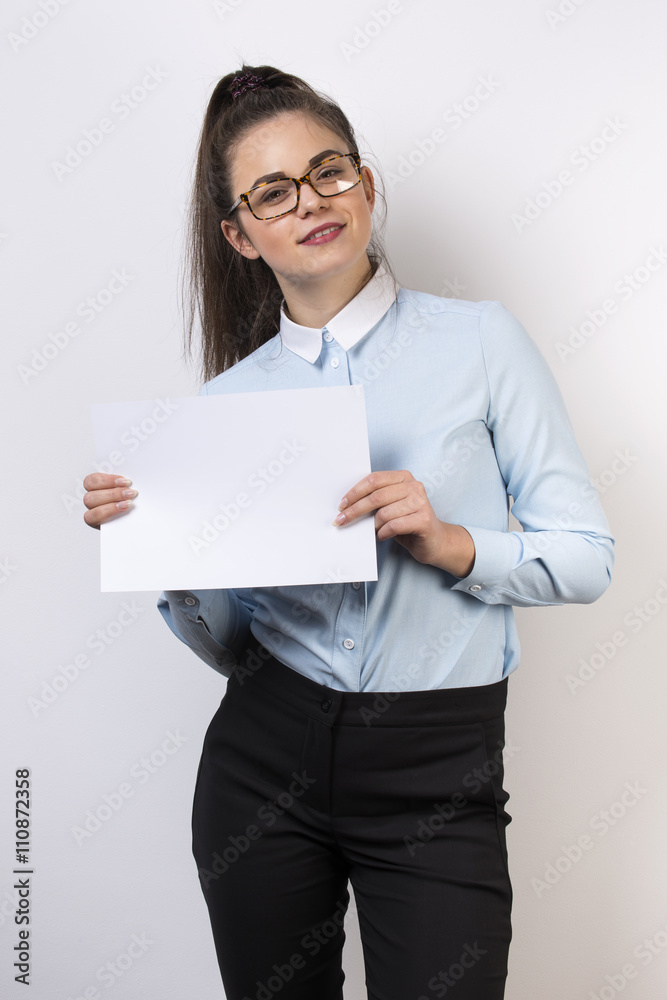 Corporate girl stands with white card presenting information Corporate girl stands with white card presenting information