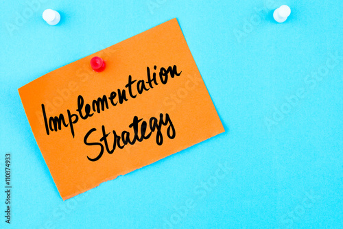 Implementation Strategy written on orange paper note