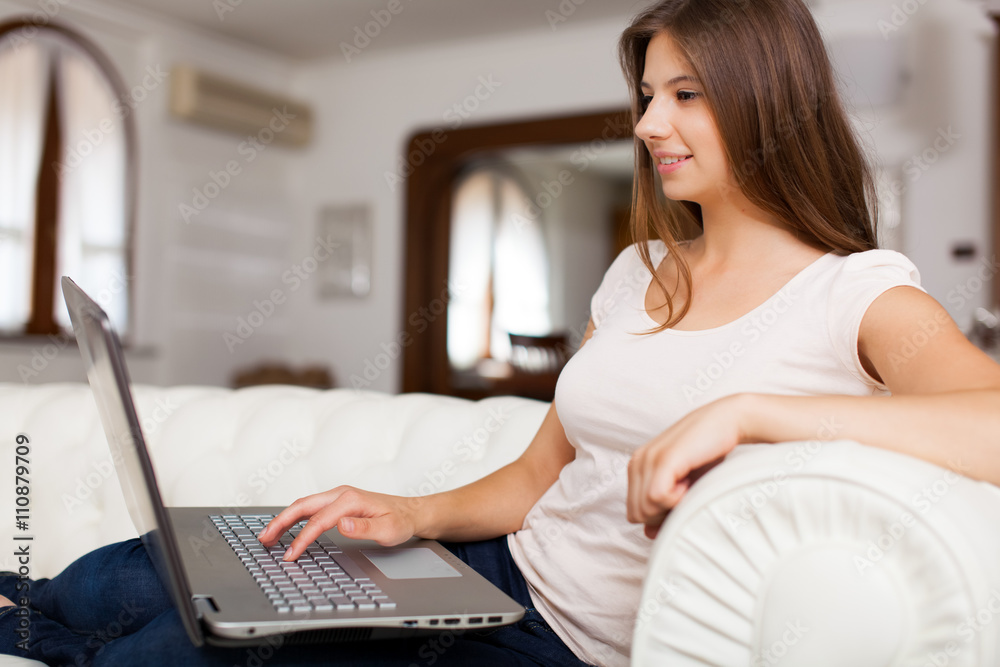 Naklejka premium Young woman relaxing with her laptop