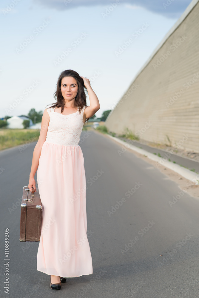 young woman with a suitcase on the road young woman with a suitcase on the road
