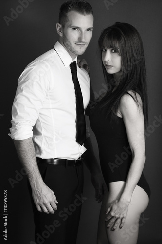 attractive couple posing over a gray background