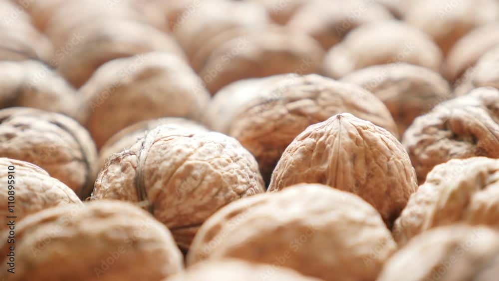 Walnuts in shells arranged on the table slow tilting 4K 2160p 30fps UltraHD video - Raw food background of walnut in the shell 4K 3840X2160 UHD tilt footage 