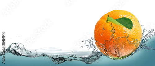 Fotografie The fruit of a ripe tangerine on a background of splashing water.
