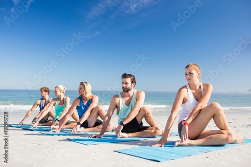 People doing yoga on the beach