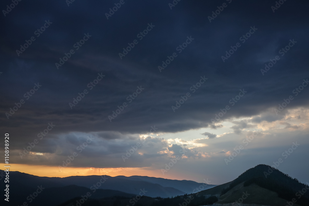 Clouds over mountains at sunset