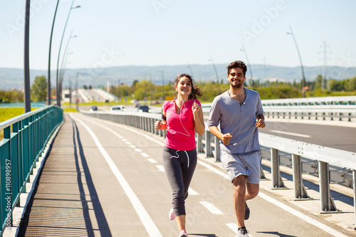 Young sport couple running together in urban environment