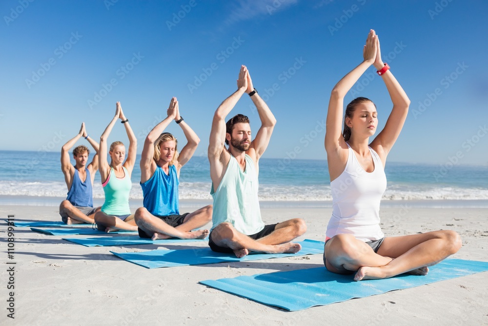 Fototapeta premium People doing yoga on the beach