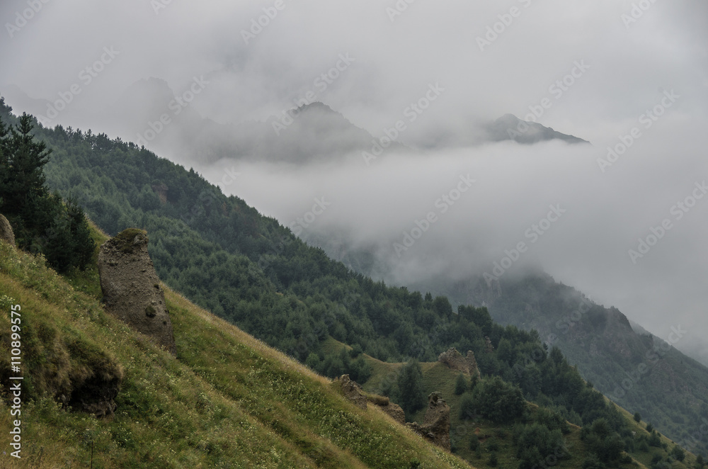 View of mountains in the clouds after storm in valley near Georgian Military Highway. Mtskheta-Mtianeti Region. Georgia, Europe