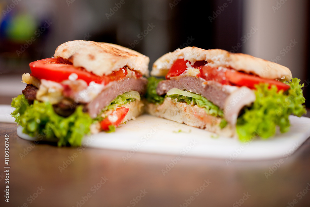Closeup of homemade hamburger with fresh vegetables Closeup of homemade hamburger with fresh vegetables