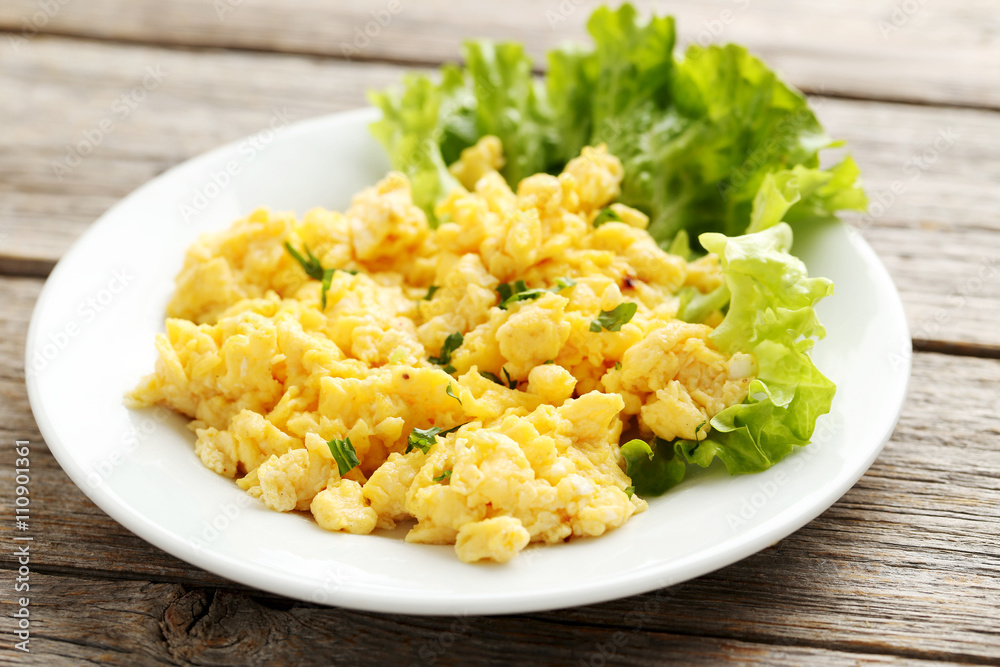 Scrambled eggs with vegetables on a grey wooden table Scrambled eggs with vegetables on a grey wooden table