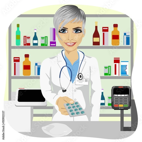 female pharmacist giving pills in blister pack standing in a drugstore in front of medications on showcase