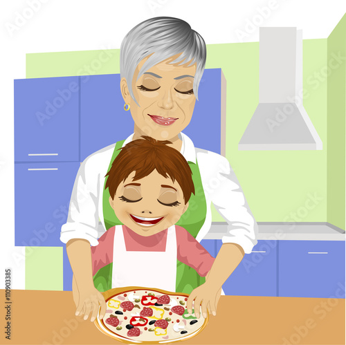 Grandmother with her grandson preparing delicious pizza together in kitchen