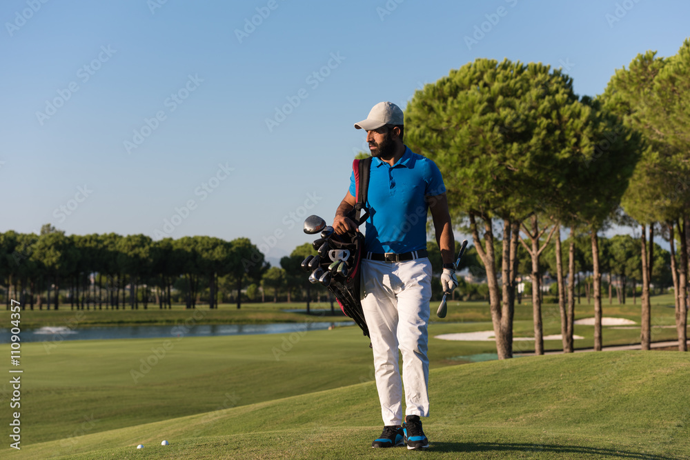 Obraz premium golfer walking and carrying bag