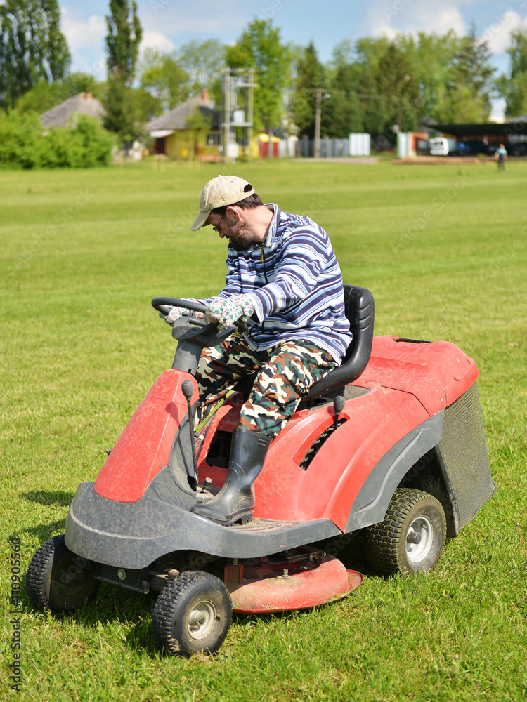 Smiling handicapped boy on lawn mower Smiling handicapped boy on lawn mower