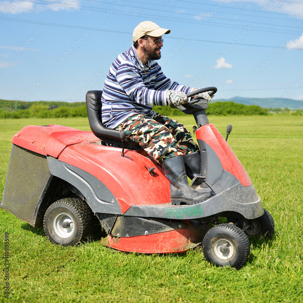 Smiling handicapped boy on lawn mower Smiling handicapped boy on lawn mower