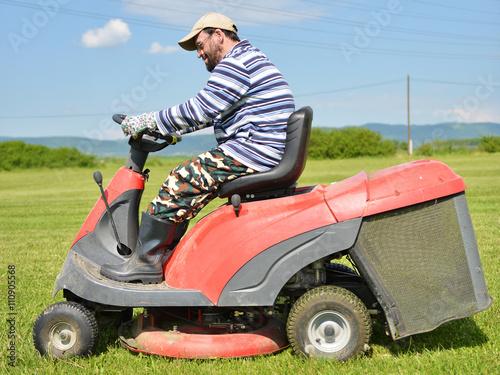 Smiling handicapped boy on lawn mower