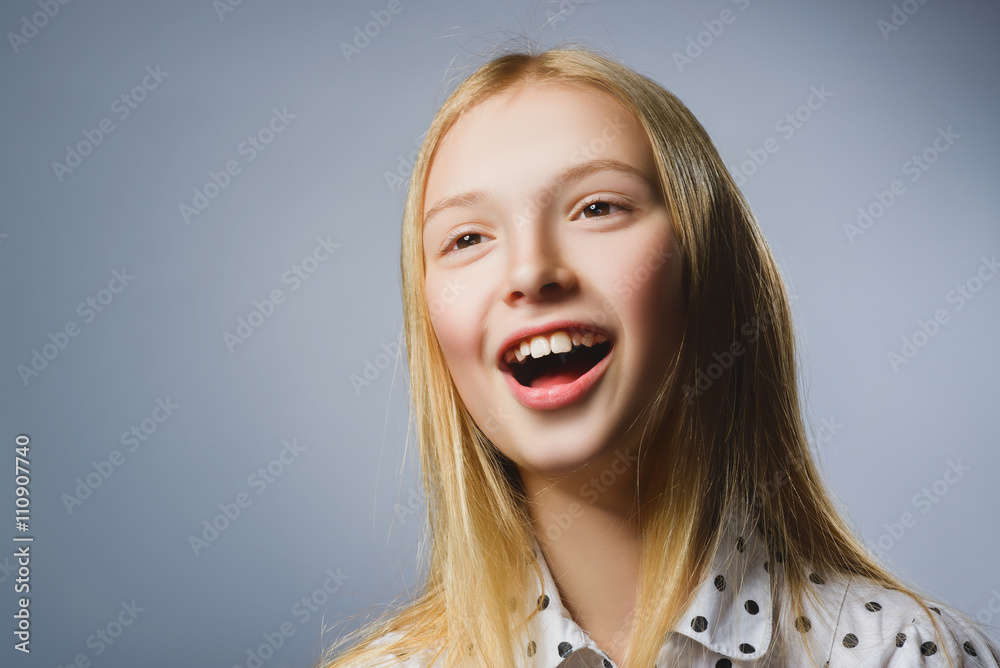 Happy girl. Closeup Portrait of handsome teen in casual shirt smiling while standing against grey background Happy girl. Closeup Portrait of handsome teen in casual shirt smiling while standing against grey background