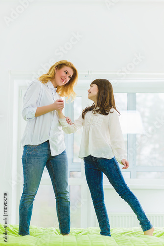 Daughter and mother are playing a fun game to bed in the living room © dreamsnavigator