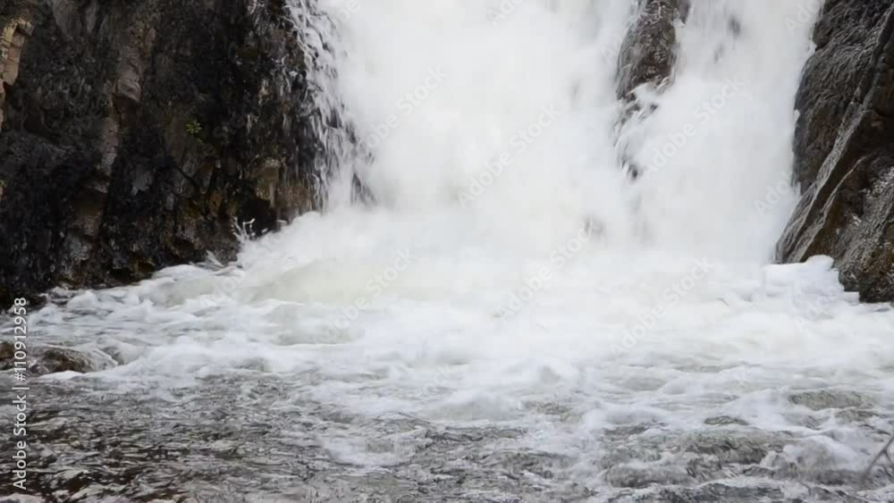 raging waterfall with foam . Water falls from the cliff and hit turns into a foam . sound of the river can be heard loudly . from the gorge follows a powerful stream of water forming a waterfall raging waterfall with foam . Water falls from the cliff and hit turns into a foam . sound of the river can be heard loudly . from the gorge follows a powerful stream of water forming a waterfall