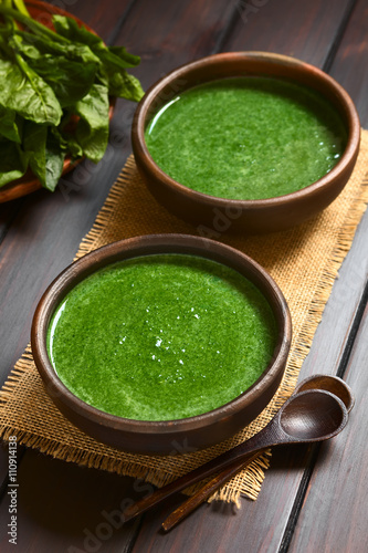 Frische Spinatcremesuppe oder Spinatrahmsuppe in rustikale Schüsseln, fotografiert mit natürlichem Licht (Selektiver Fokus, Fokus in die Mitte der ersten Suppe)