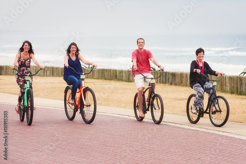Mother and her fully grown children riding bicycles together
