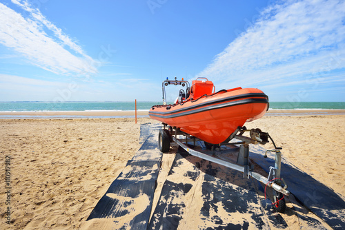 Red patro lifeguard boat loaded on a trailer at the beach on a s photo