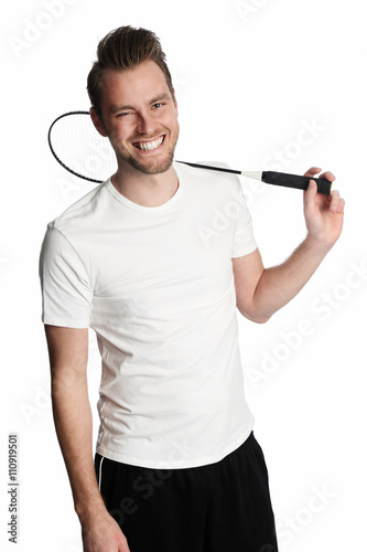 Attractive man in his 20s wearing a white tshirt and black shorts standing holding a badminton racket. White background.