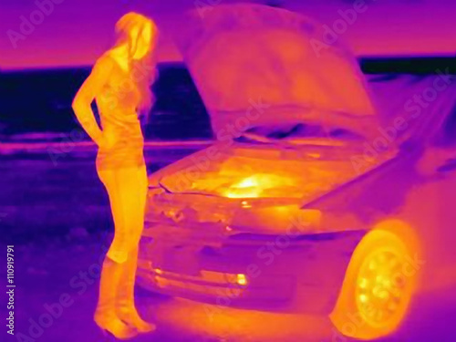 Thermal image of woman looking at automobile engine on roadside photo