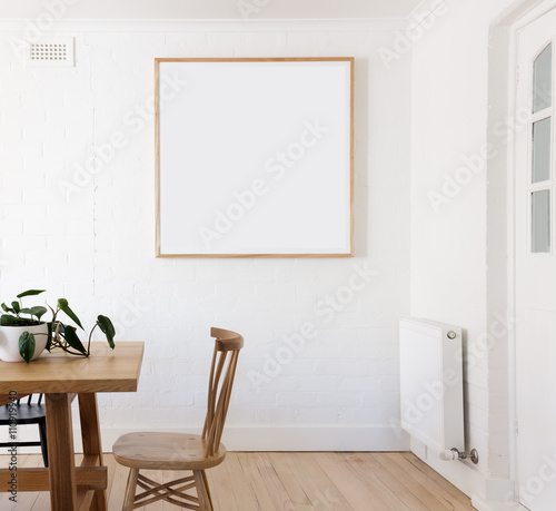 Blank framed print on white wall in danish styled interior dinin