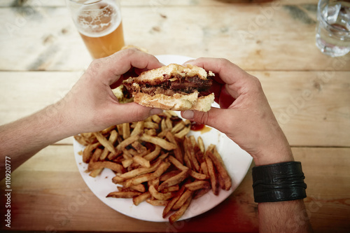 Man holding half eaten burger