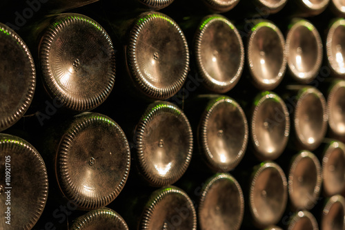 Dusty old wine bottles stacked in the wine cellar