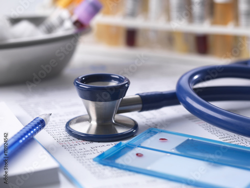 Health check with stethoscope, results, blood, urine and chem samples on doctors desk photo