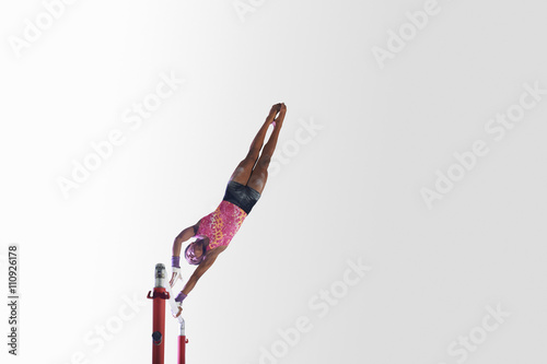 Young gymnast performing on uneven bars