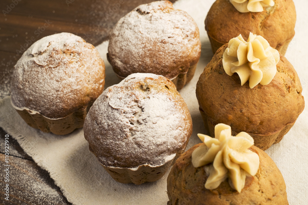 Fototapeta premium Sweet, lush cupcakes with cream and dusted with powdered sugar