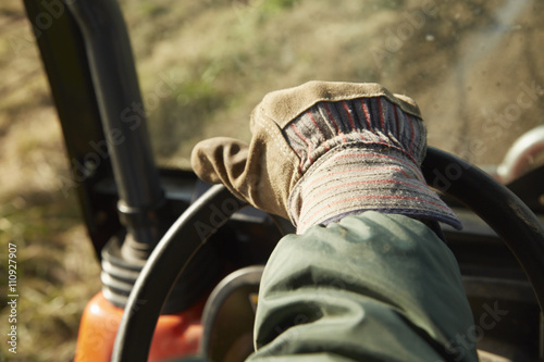 Close up of male hand driving tractor dairy farm field