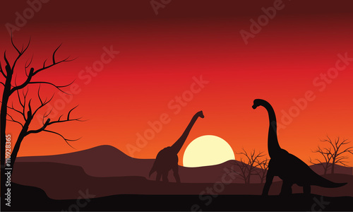 Silhouette of two brachiosaurus at sunset