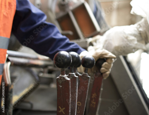 Close up of factory workers hand operating levers in concrete reinforcement factory