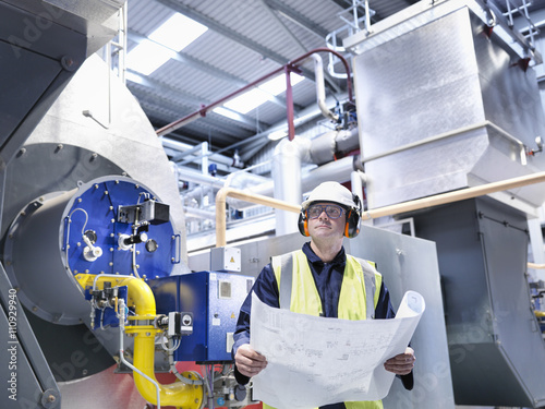 Worker with schematic drawings in gas fired power station photo