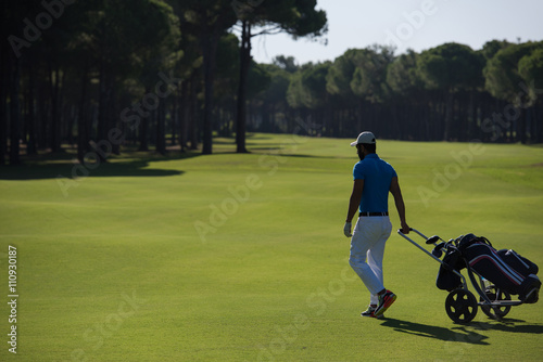 golf player walking with wheel bag