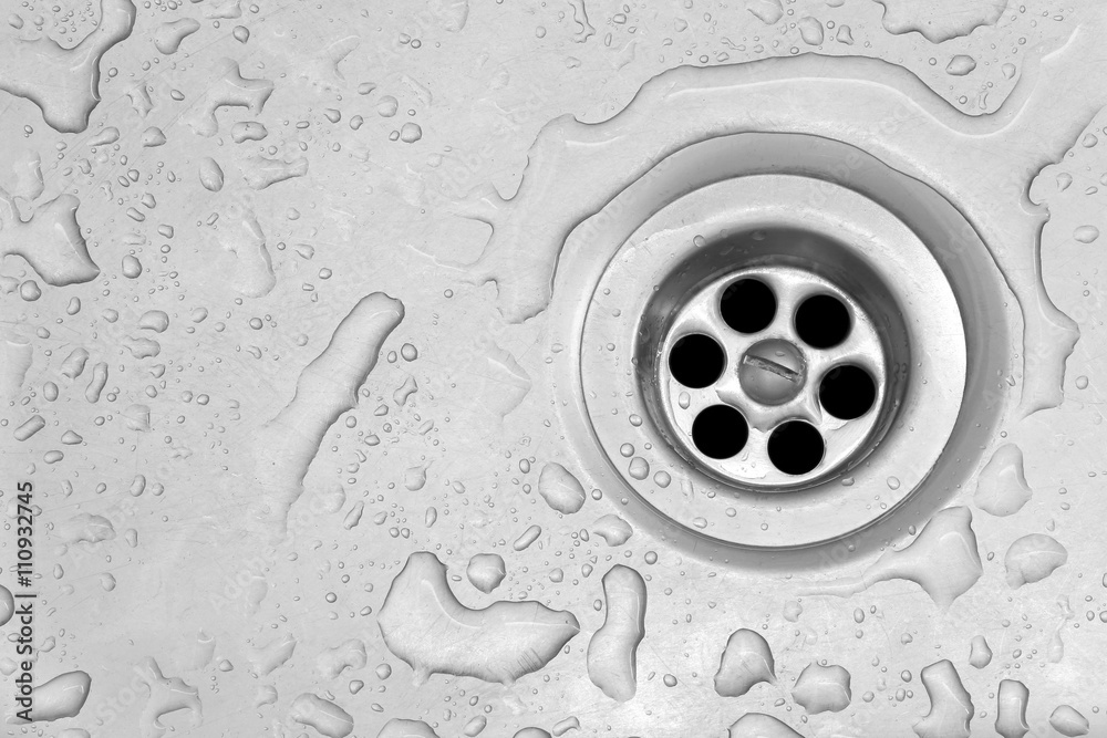 View of the sink, drain and flowing water for background
