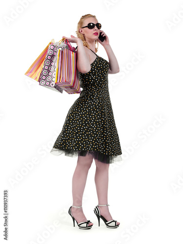 young woman holding shopping bags and communication over cellphone.