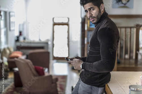 Portrait of young man holding cell phone photo
