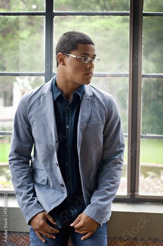 Mature teenage boy in front of window looking sideways