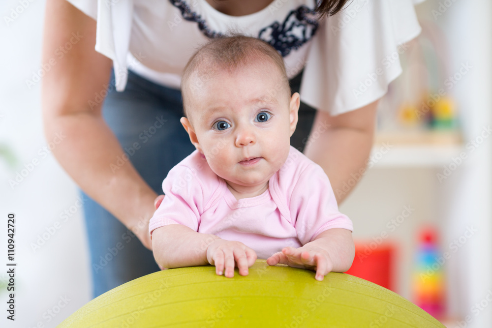 Mother and baby playing on fitness ball Mother and baby playing on fitness ball
