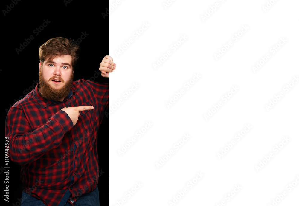 Nice guy pointing in surprise at a white wall Nice guy pointing in surprise at a white wall